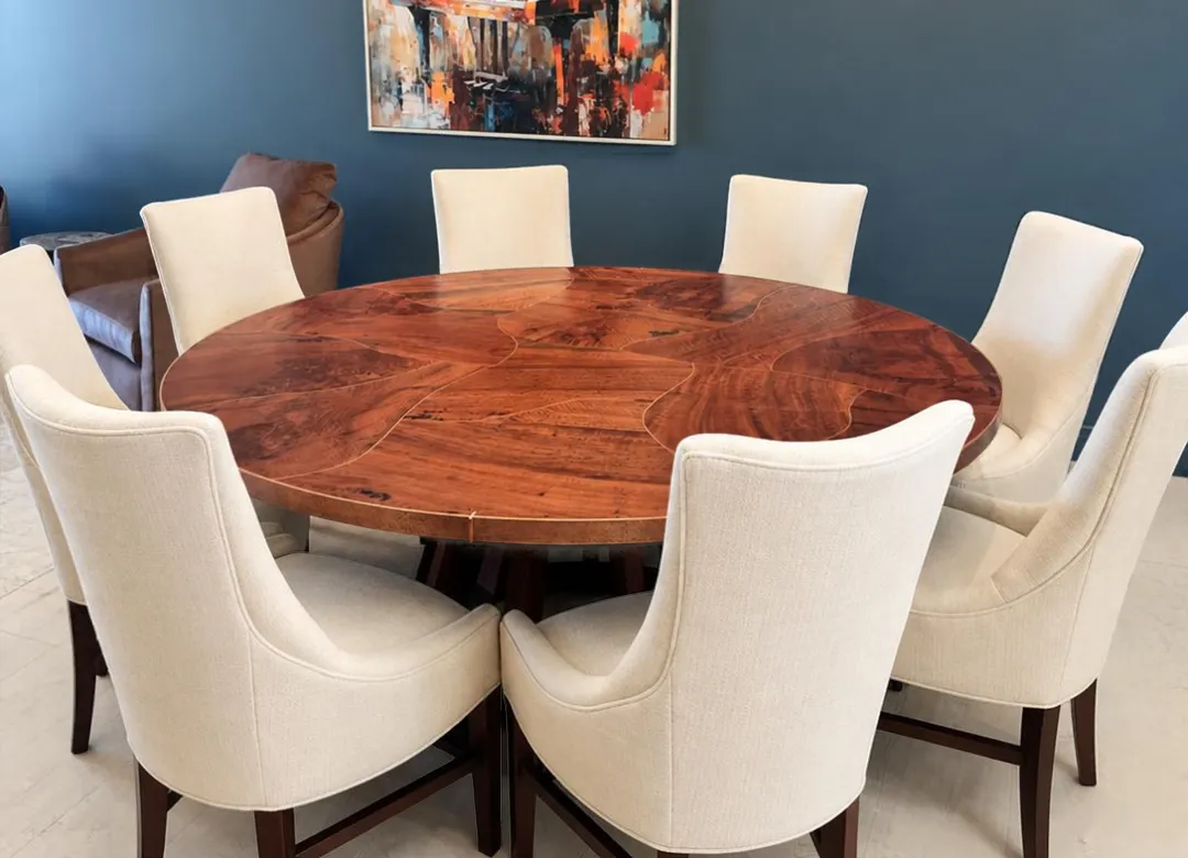 Round eucalyptus copper inlay dining table Round eucalyptus copper inlay dining table with eight cream upholstered chairs in a dining room with a blue wall