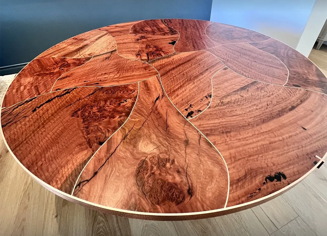Finished eucalyptus copper inlay dining table with the inlay tracing the curved puzzle-piece seams Finished eucalyptus copper inlay dining table with the inlay tracing the curved puzzle-piece seams